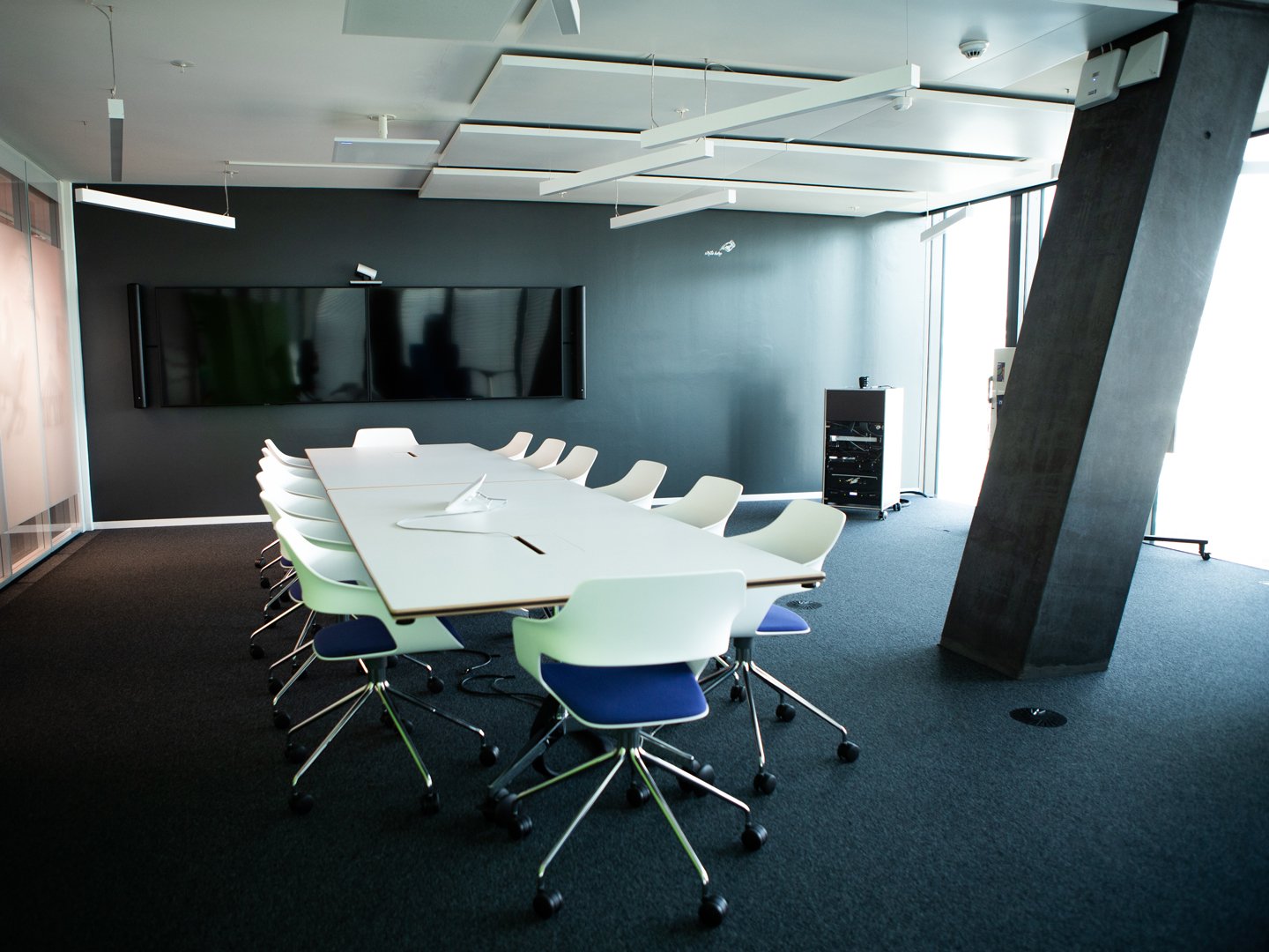 Large meeting room at Cognizant with displays and many chairs and a table